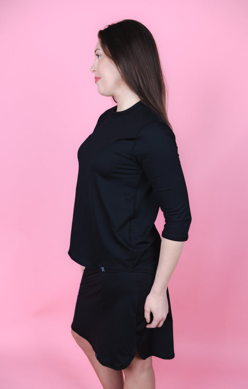 Transcendent Active Performance Quarter Sleeve Top in black, featuring a modest, athletic fit with quarter-length sleeves, smooth performance fabric, and a flattering silhouette designed for movement and everyday wear.