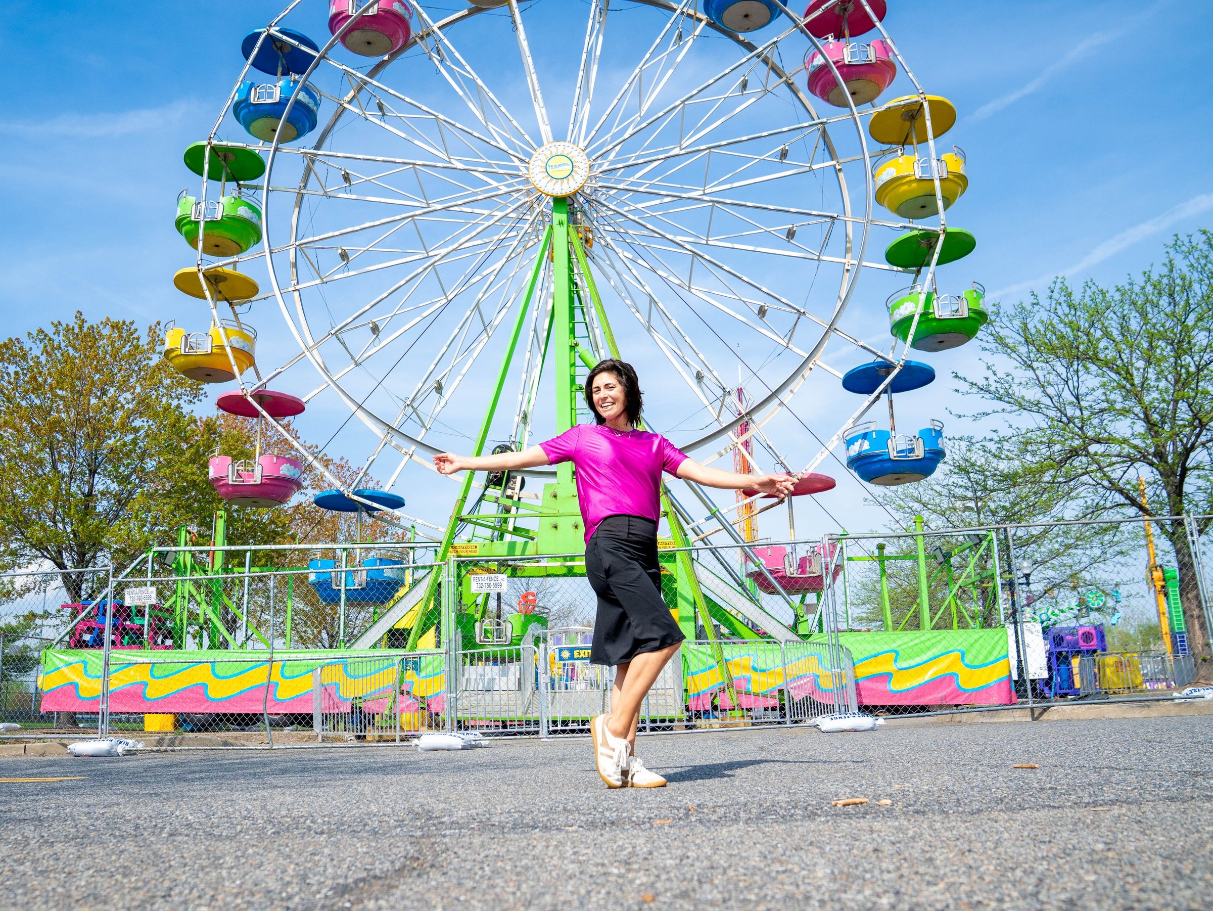 Aja of Transcendent Active in front of a Ferris wheel